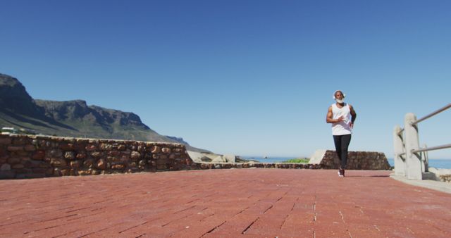 Young man jogging on scenic pathway by ocean - Download Free Stock Images Pikwizard.com