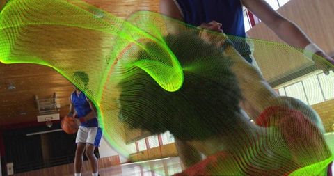 Dynamic basketball dribble with neon overlay in gymnasium