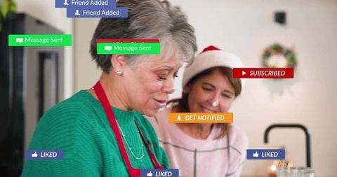 Senior women baking cookies and sharing holiday cheer with social media notifications