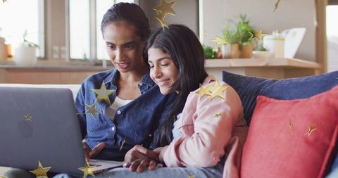 Mother guiding teenage daughter on laptop at home with golden star overlays