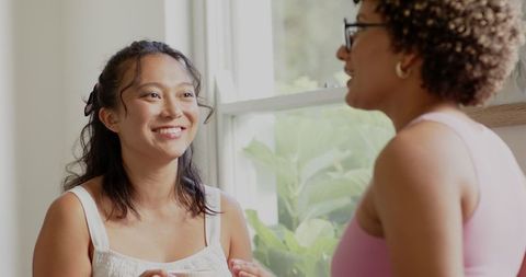 Two Women Engaged in Heartfelt Conversation by Sunlit Window