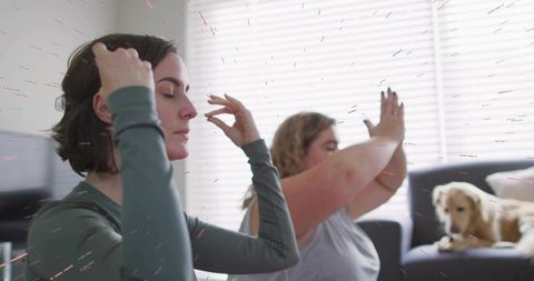 Women practicing mindful breathing at home with dog relaxing on sofa, calm meditation