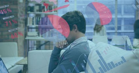 Mid-adult man thinking and analyzing data overlays in coworking space with dashboards