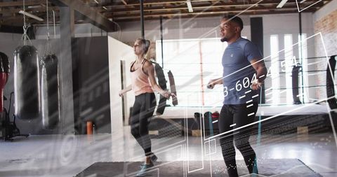 Skipping partners doing jump-rope cardio in industrial boxing gym with futuristic hud overlay