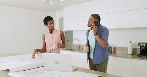 Couple Collaborating on Home Blueprint Design in Modern Kitchen