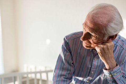 Thoughtful Elderly Man Sitting Alone in Sunlit Room