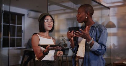 Diverse Women Collaborating on Technology in Modern Office