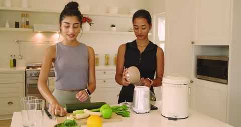 Diverse friends preparing fresh produce in modern kitchen