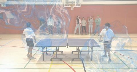 Playing recreational table tennis match in school gym with cheering spectators