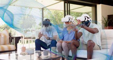 Adults experiencing virtual reality together on sofa, wearing vr headsets and reaching out