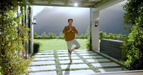 Man Practicing Tree Pose on Tranquil Patio with Mountain View