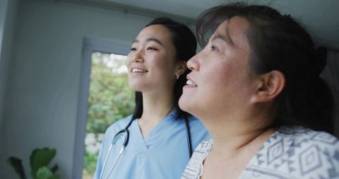 Nurse and patient looking out window during consultation showing caring support