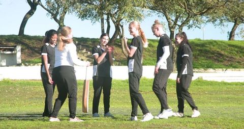 Diverse Female Teen Cricket Team Celebrates Outdoors