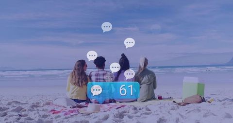Four friends relaxing by ocean chatting away on scenic beach