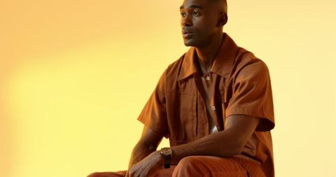 Stylish man checking wristwatch in modern studio