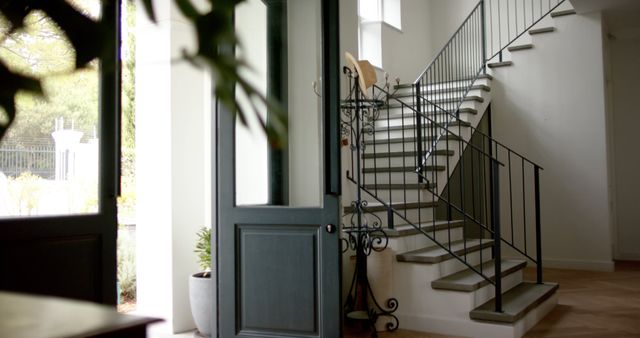 Close up of opened front door and staircase at home. Lifestyle, interior decor and domestic life, unaltered.