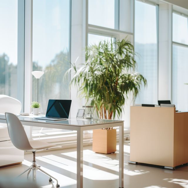 Bright and airy office with a minimalist design, featuring a sleek desk with a laptop, green plants, and large windows letting in ample natural light. Ideal for use in articles or marketing materials related to contemporary work environments, productivity, and professional settings.