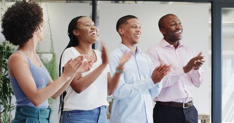 Diverse team celebrating success in office with applause
