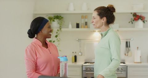 Diverse Workout Partners Engaging in Active Kitchen Conversation