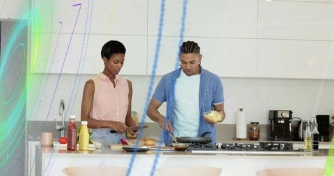 Couple preparing breakfast with bagels, cheese and coffee in modern minimalist kitchen