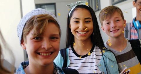 Smiling teenage girl wearing patterned headband and striped shirt with friends in school hallway