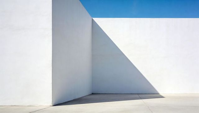Minimal White Architecture with Sharp Triangular Shadow and Blue Sky