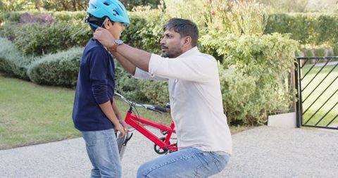 Father Securing Son's Helmet for Outdoor Adventure