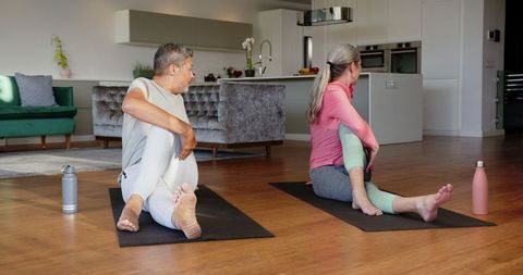 Couple Practicing Yoga at Home for Wellness and Relaxation