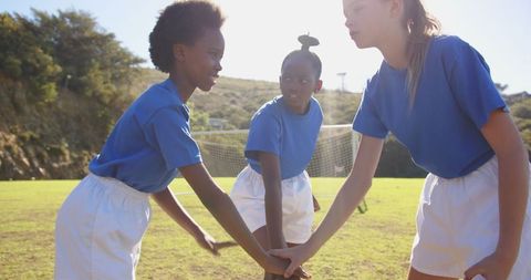 Diverse School Girls Joining Hands in Soccer Team Unity