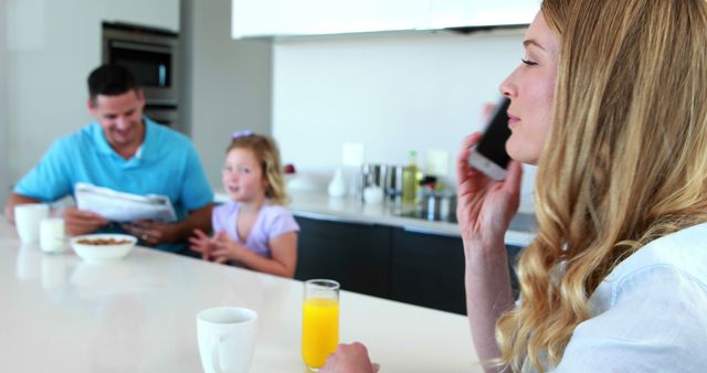 Happy family in kitchen with daughter playing and mother on smartphone - Download Free Stock Images Pikwizard.com