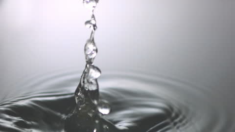 Water Droplet Creating Ripples on Calm Surface