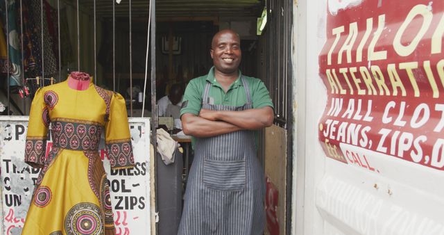 Tailor standing with arms crossed outside shop displaying handmade dress - Download Free Stock Images Pikwizard.com