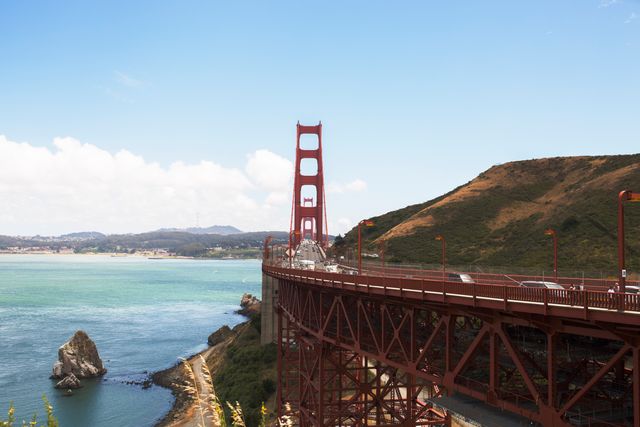 Golden Gate Bridge on a sunny day with clear blue skies. Ideal for promoting San Francisco tourism, traveling inspiration, architectural marvels, or transport-related themes. Suitable for use in travel brochures, marketing campaigns, and blog posts.
