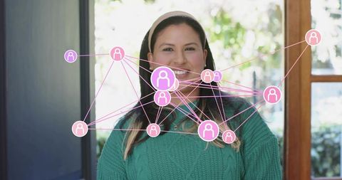 Smiling woman in green sweater with pink digital social network overlay showing connectivity