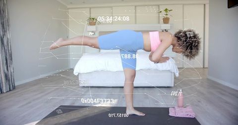 Woman performing single-leg balance yoga with augmented reality fitness overlay at home