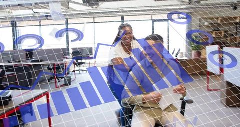 Playful coworkers pushing colleague in rolling chair with digital growth charts overlay