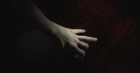 Creepy hand crawling in dark, eerie ambiance for halloween