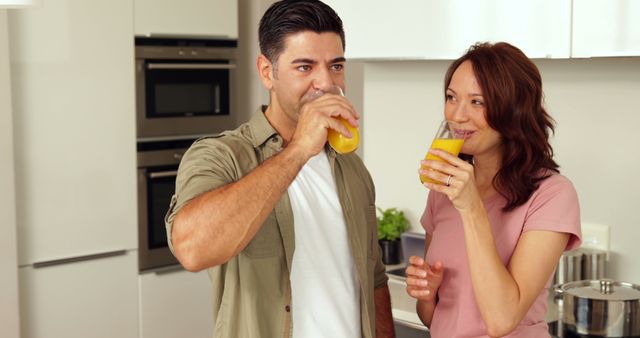 Couple Enjoying Fresh Orange Juice in Modern Kitchen - Download Free Stock Images Pikwizard.com