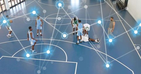 Basketball team gathering around injured player on court, coach walking, analytics overlay