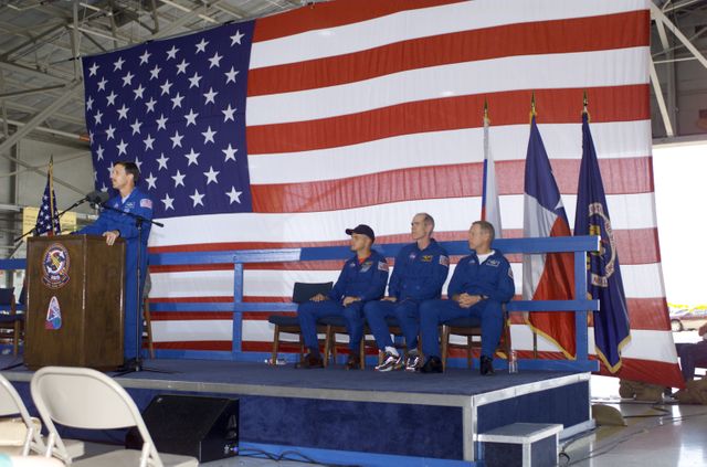 JSC2001-E-25817 (23 August 2001) --- Scott J. Horowitz, STS-105 commander, speaks from the podium in Hangar 990 at Ellington Field during the STS-105 and Expedition Two crew return ceremonies.  The rest of the STS-105 crew are seated on the right - Frederick W. Sturckow, pilot, Daniel T. Barry, mission specialist, and Patrick G. Forrester, mission specialist.  The STS-105 crew delivered the Expedition Three crew and supplies to the International Space Station (ISS) and brought the Expedition Two crew back to Earth.