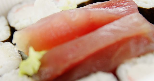 Close-up of a delicious sushi selection featuring fresh tuna on top of rice, with a hint of wasabi on the side. Sushi is a traditional Japanese dish enjoyed worldwide for its unique taste and presentation.