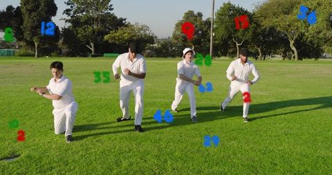 Four cricketers practicing running and bowling on sunlit grass wearing white kits with colored numbe