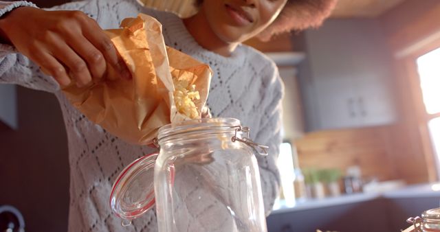 Woman Pouring Popcorn into Mason Jar in Sunlit Kitchen - Download Free Stock Images Pikwizard.com