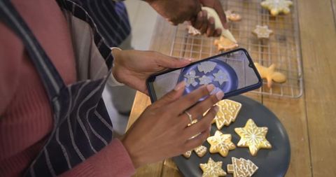 Couple Decorating Christmas Cookies Photographing with Smartphone for Social Sharing