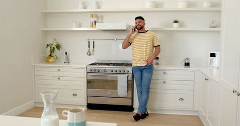 Man Talking on Smartphone in Modern Minimalist Kitchen