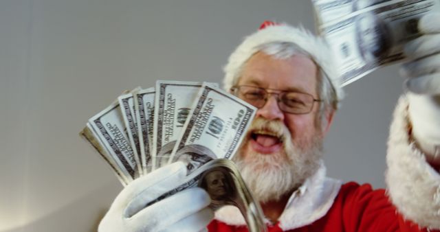 A Caucasian man dressed as Santa Claus is joyfully throwing money towards the camera, with copy space. His cheerful expression and the festive costume suggest a holiday-themed concept related to generosity or celebration.