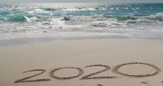 2020 written in sand on beach with ocean waves - Download Free Stock Images Pikwizard.com