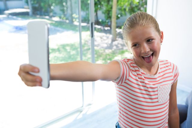 Playful Girl Taking Selfie by Window at Home - Download Free Stock Photos Pikwizard.com