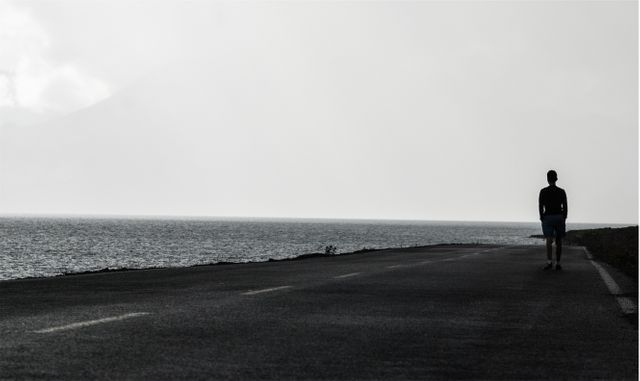 Solitary Person Walking on Coastal Road During Overcast Day - Download Free Stock Images Pikwizard.com