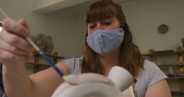 Masked Woman Engaged in Pottery Painting in Art Studio - Download Free Stock Images Pikwizard.com